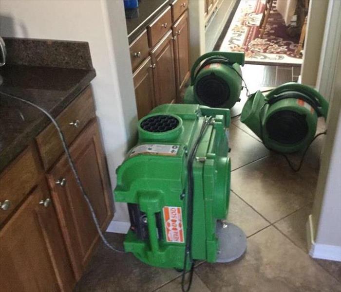 SERVPRO equipment drying out a flooded kitchen and cabinets