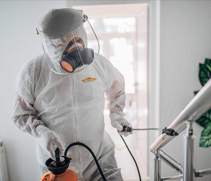 SERVPRO Technician wearing PPE and disinfecting a contaminated area